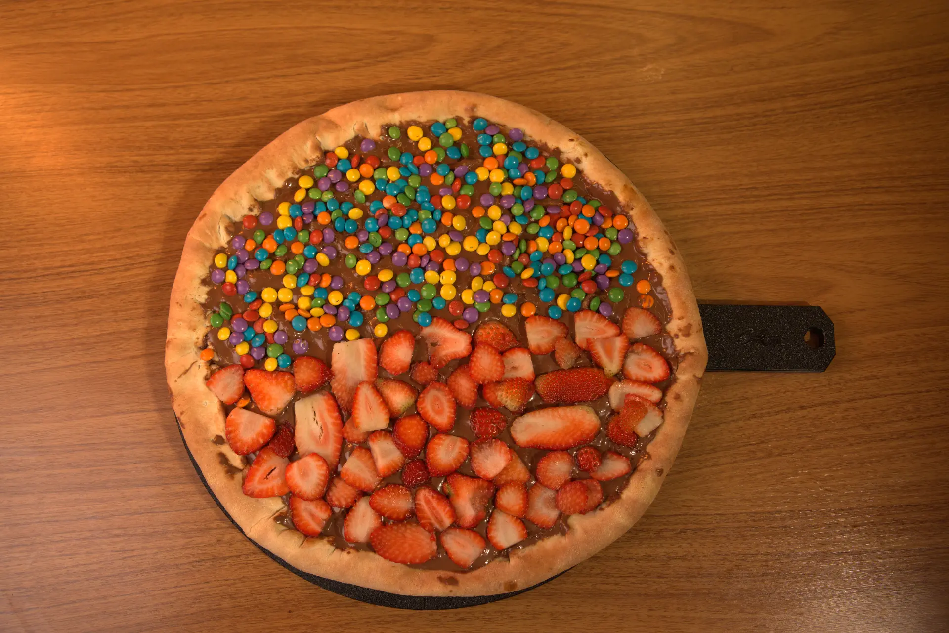 Pizza doce com cobertura de chocolate e confeitos
